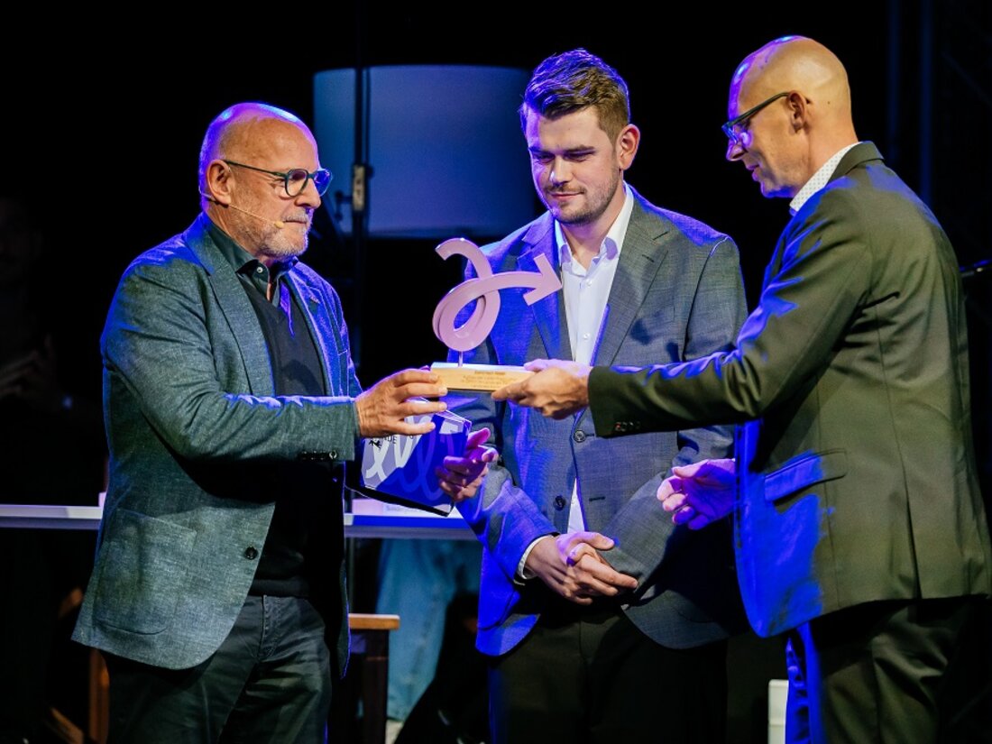 Verkehrsminister Hermann übergibt eine Trophäe an zwei männliche Personen für die Kategorie Elektrisch Mobil.