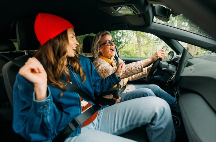 2 gut gelaunte Frauen fahren im Carsharing-Auto zusammen