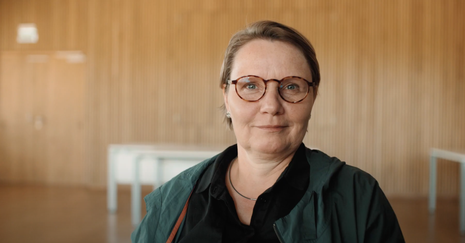 Eine Frau mit Brille in einem Raum. 