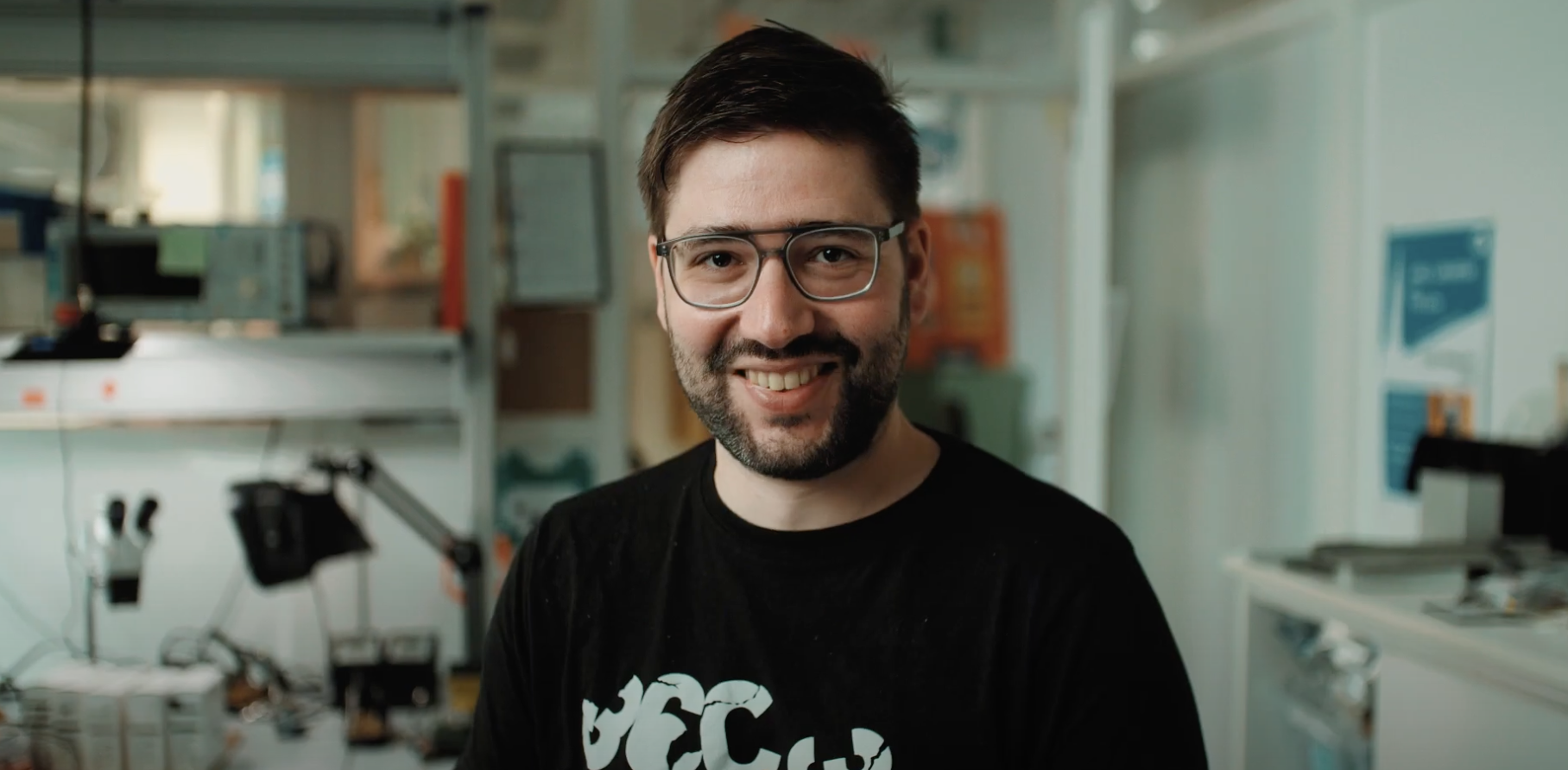 Mann mit Brille steht in einem Büro.